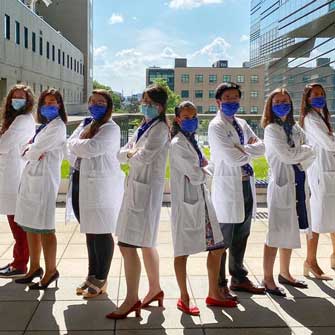 Members of the School of Medicine stand proudly in white coats.