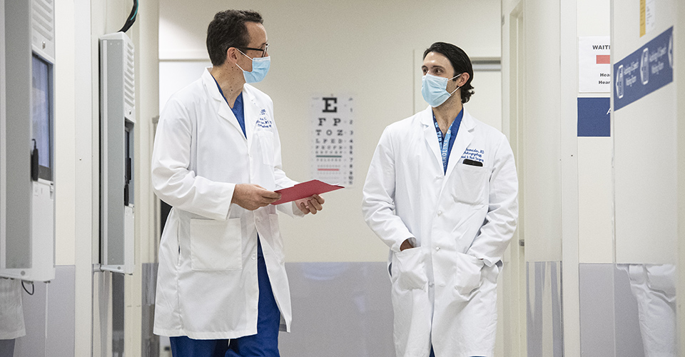 Otolaryngology faculty walking down a hallway, wearing masks.