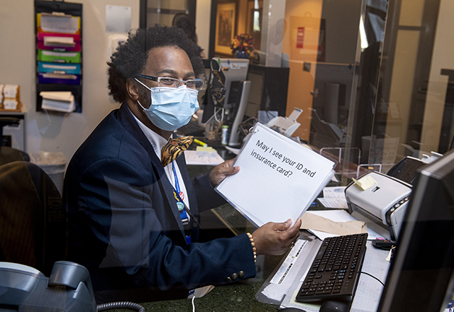 staff wearing clearing mask while holding key cards