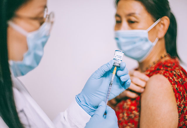 a provider preps a vaccine for a patient