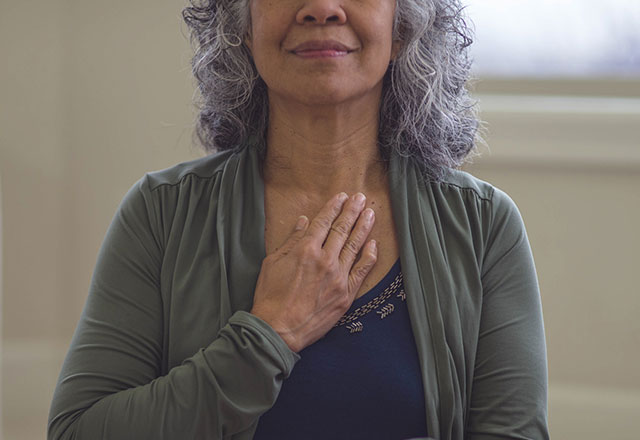 An older woman doing deep breathing exercises