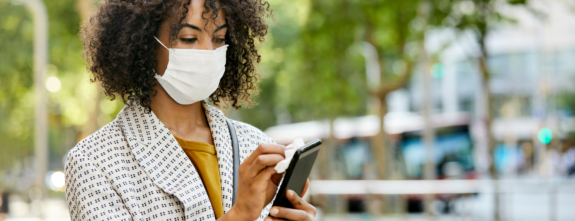 woman on her phone while wearing a face mask