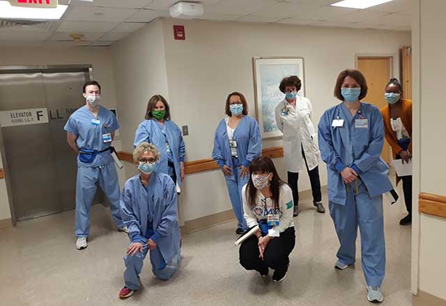 Group of staff members standing together and smiling.