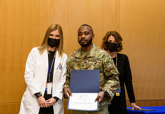 Dr. Miller and Kris Lukish pose with National Guard member Njeck.