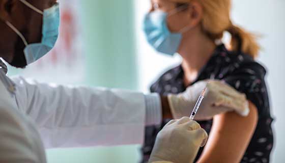 Doctor administering a vaccine to a patient