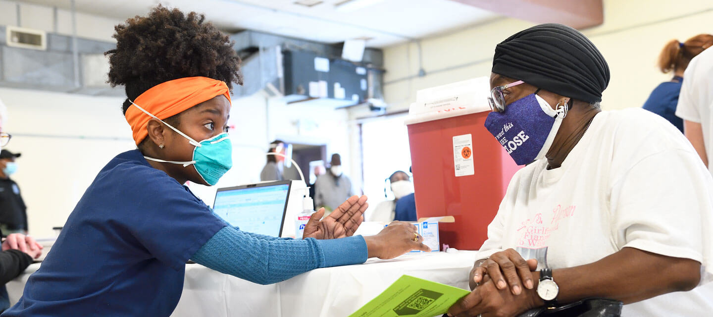 A Johns Hopkin employee giving a vaccine to a patient