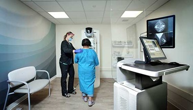 Provider prepares woman for a breast exam