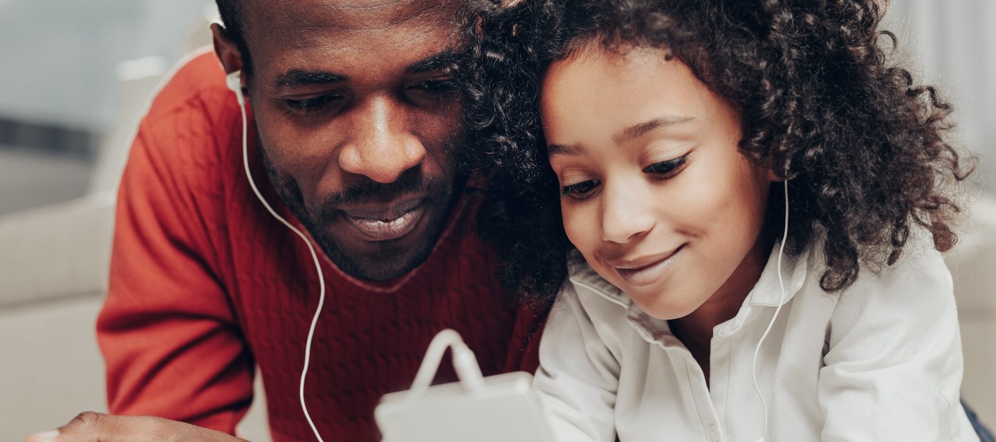 Daughter and dad sharing headphones