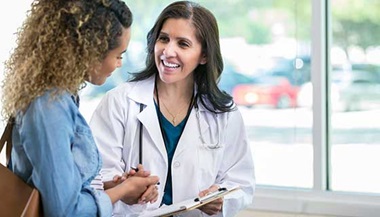 A doctor speaks with a young woman.