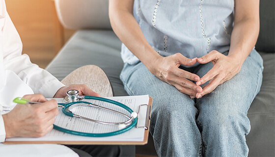 doctor holds clipboard speaks to patient