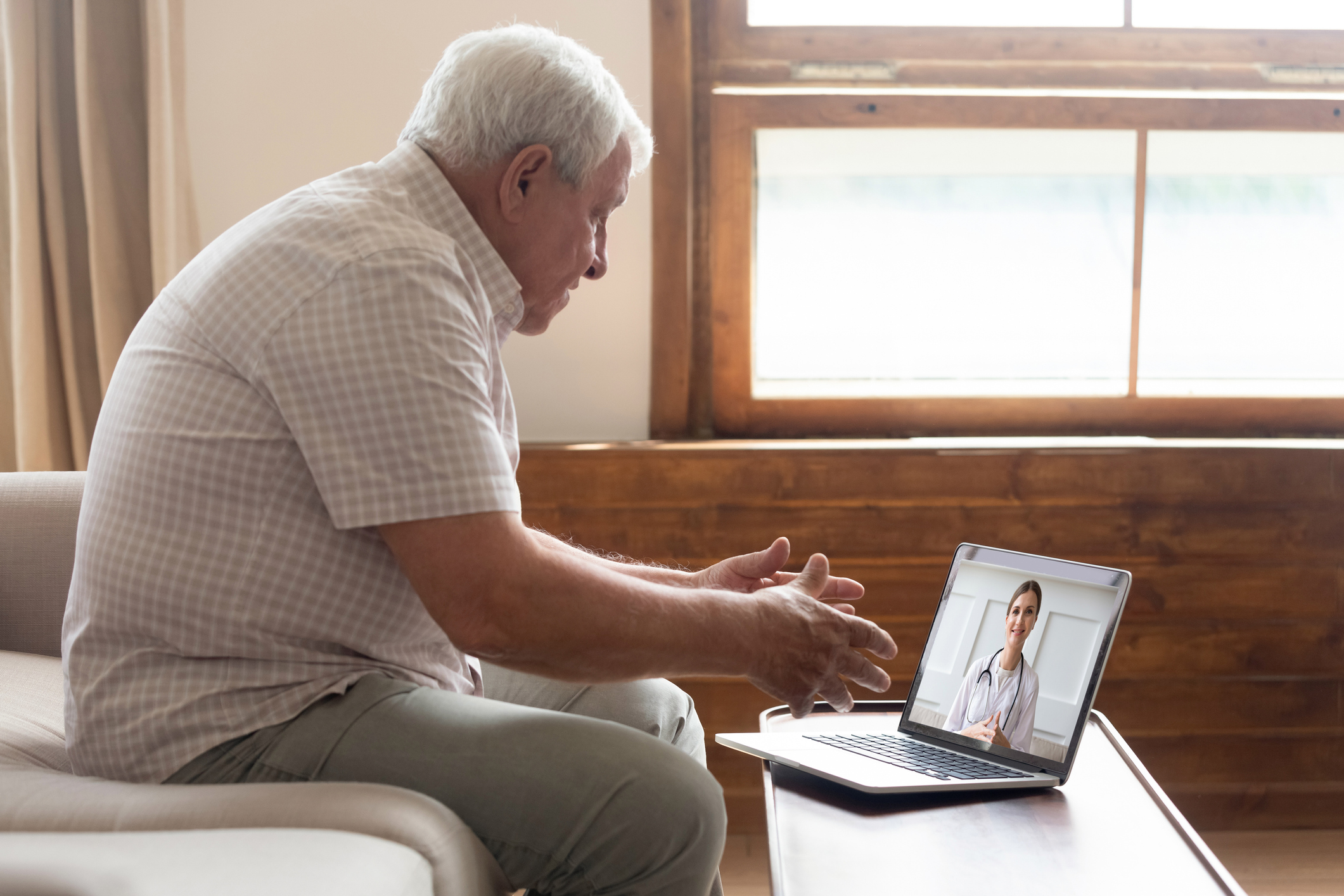 older man making a telemedicine appointment via laptop