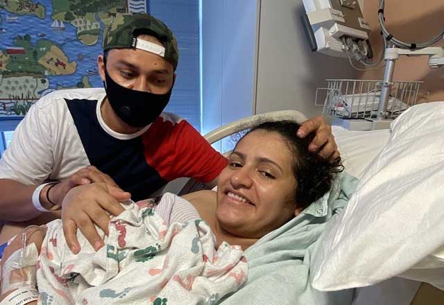 Elsa in hospital bed with newly born Sofia and husband Victor at their side.