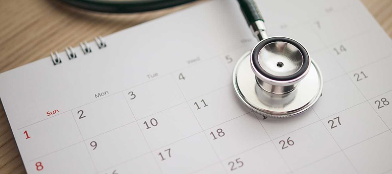 stethoscope sitting atop a monthly calendar