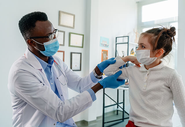 a pediatrician and a smiling young patient