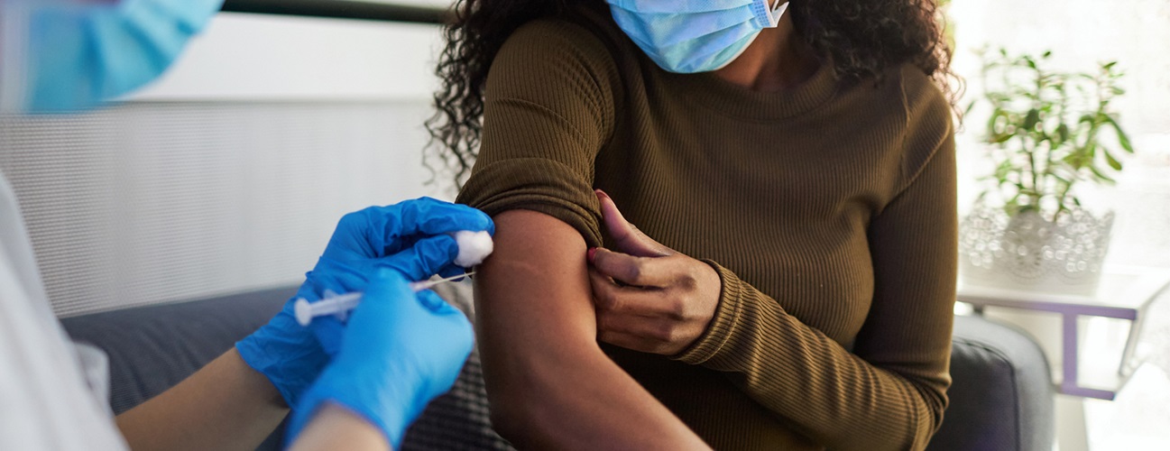 full fda approval covid vaccine - healthcare provider giving vaccine to woman.