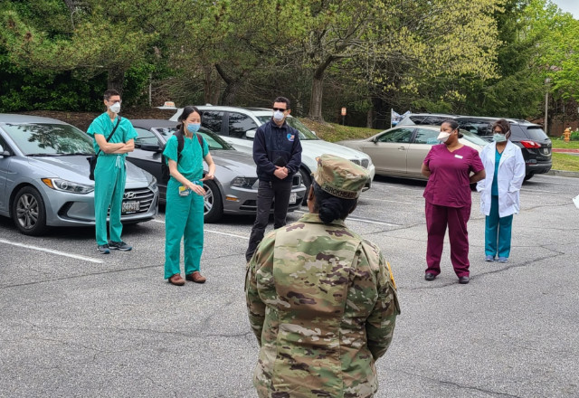 Members of the Go Team, facility staff and the National Guard meet in a parking lot