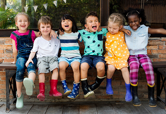 A group of happy children sit together.