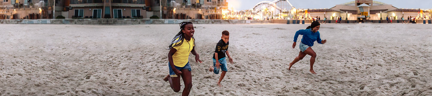 three kids running on a beach