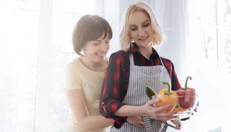 A lesbian couple cooks together.