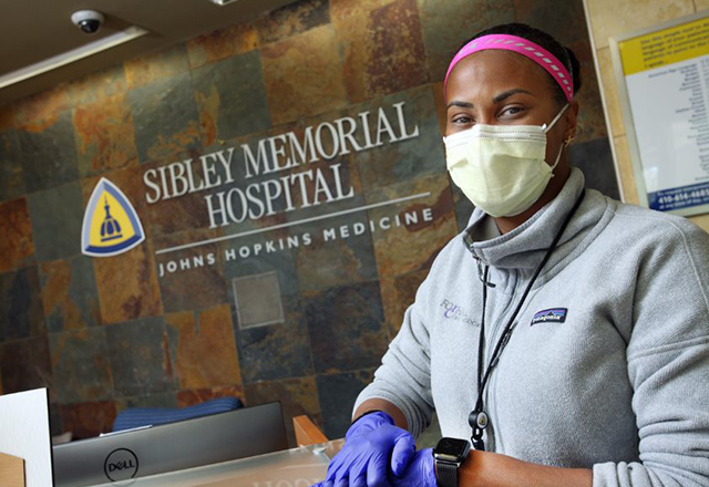 Lynne Lightfoote stands in front hospital