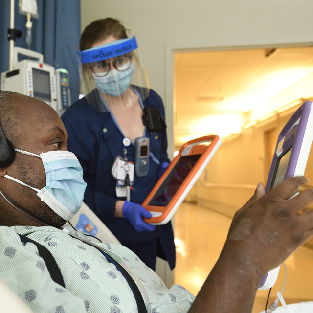 A photo shows a patient in the hospital using a tablet. 