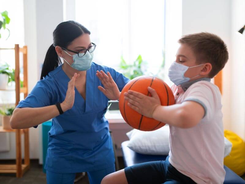 Physical therapist going through exercises with a child at home