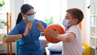 Physical therapist helps a child exercise