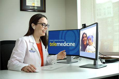 a doctor sits in her office conducting a telemedicine appointment