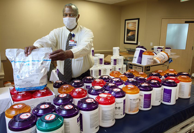 Roark Nixon stands in front of disinfectants