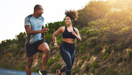 Two happy people run together.