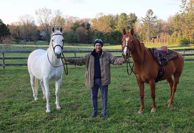 a former COVID-19 patient poses with his two horses