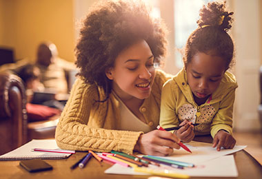 A mom helps her young daughter with her homework