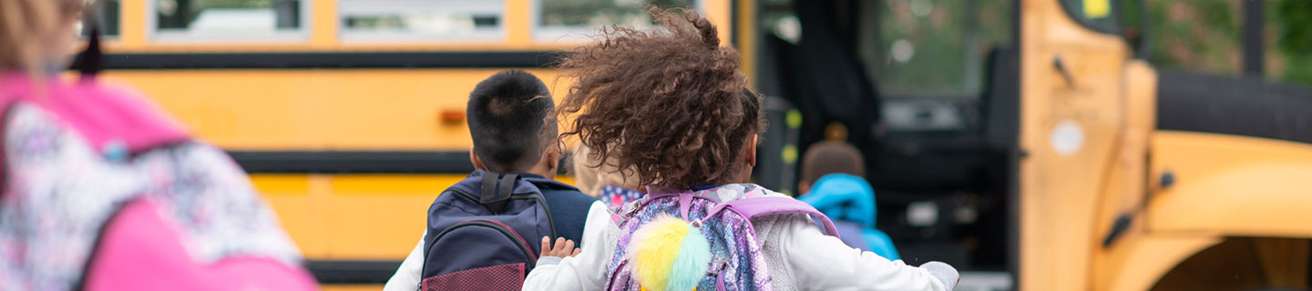 children running to catch a school bus