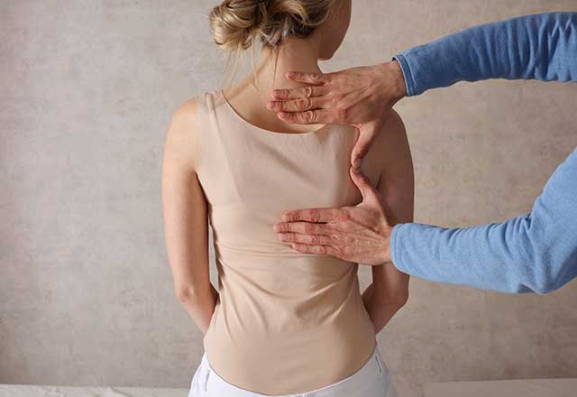 Doctor examining a patient's back.