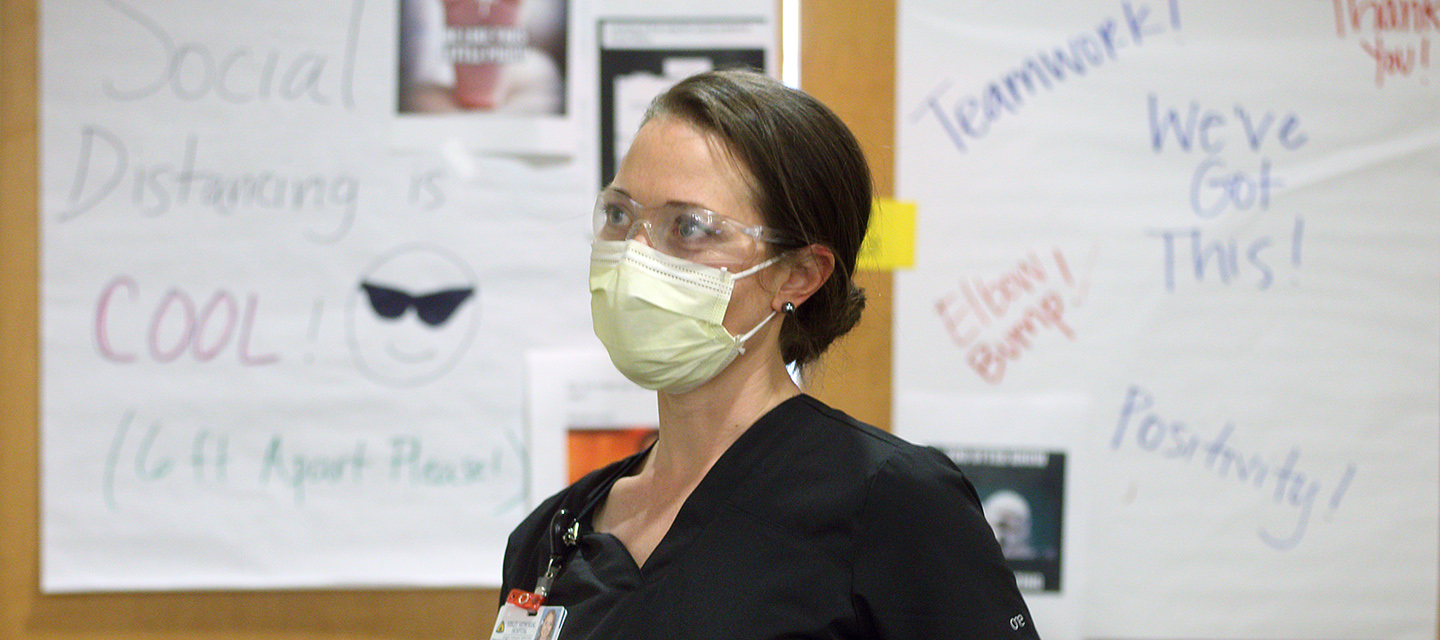 Mellaknese Coker, R.N., pushes a nursing cart down a hallway.