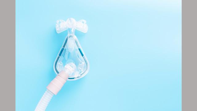 a CPAP sleep mask on blue background