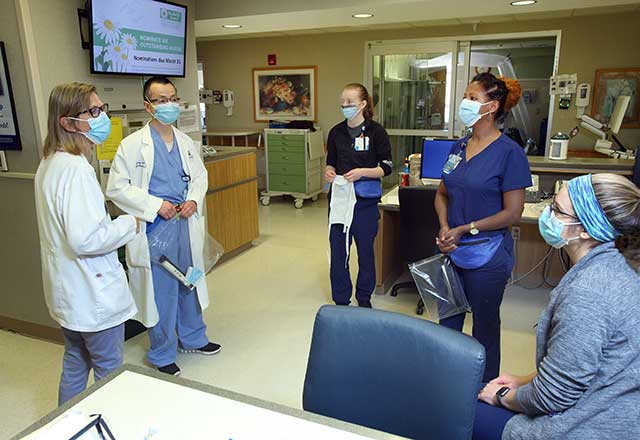 Providers discussing while wearing masks.