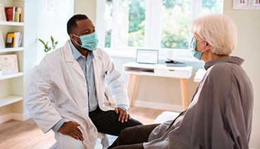 Surgeon speaking with a patient in a sunny room