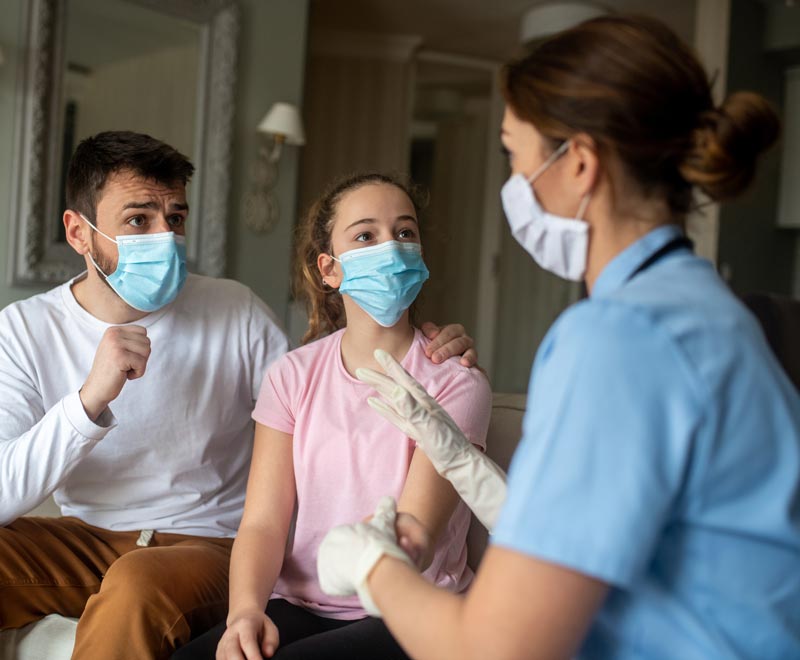 Father and teen patient discuss health concerns with pediatric nurse