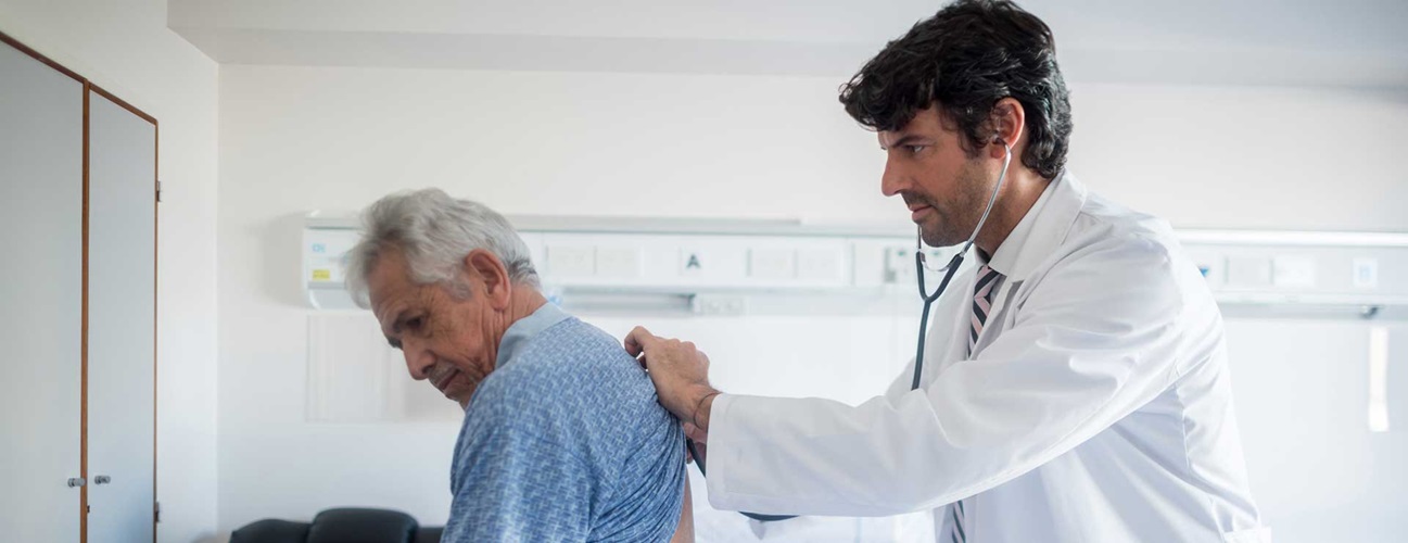 Doctor listening to patient lungs using a stethoscope