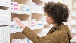 Woman browsing a pharmacy aisle.