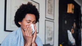 Woman blowing her nose