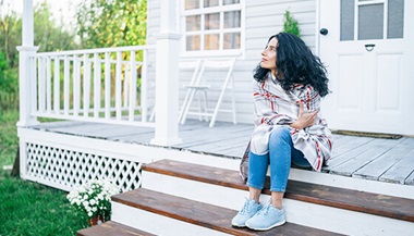 woman sits on step thinking