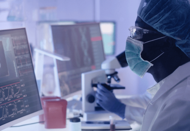 scientist working in a lab, looking at a computer