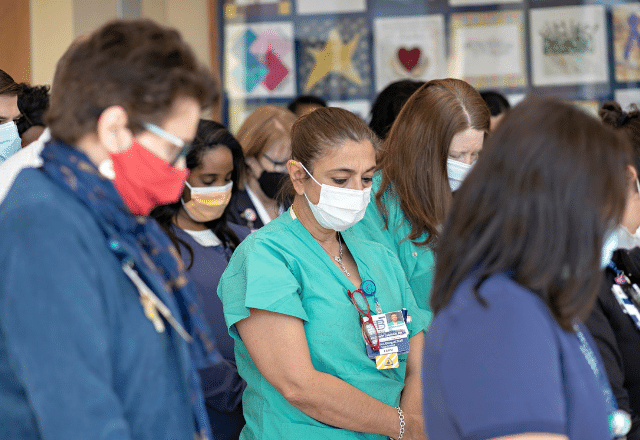 staff with head bowed during moment of silence