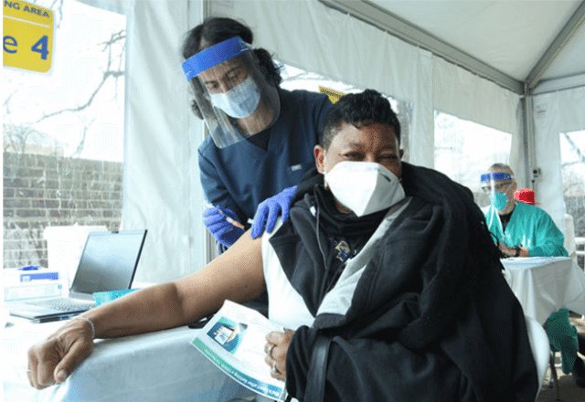 patient receiving a vaccine at an outdoor clinic