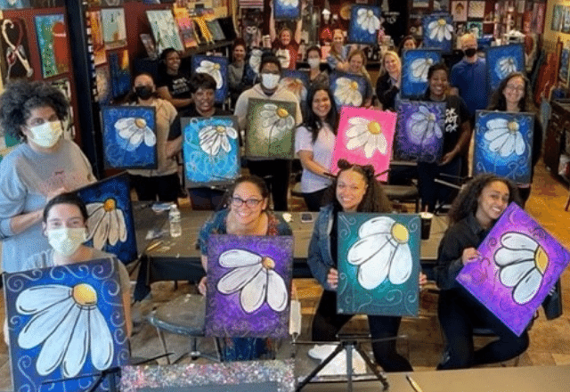 paint night event- group holding their paintings