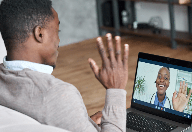 man waving at a doctor on the computer screen